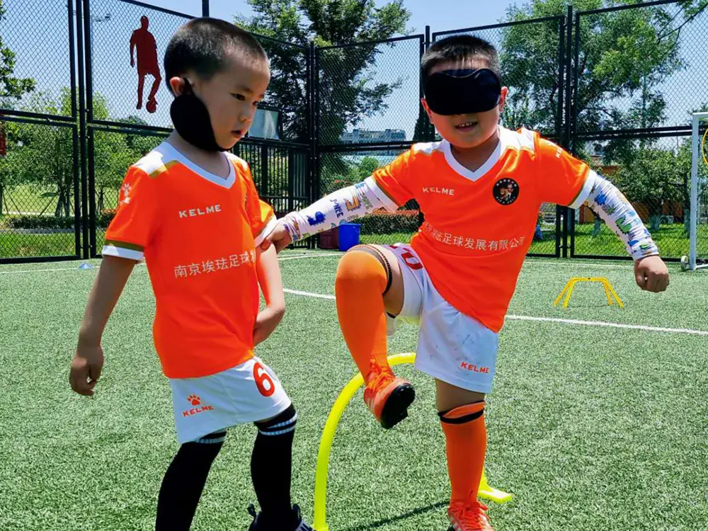 Young players in orange kits practising ball control